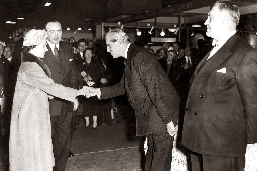 Black and white historical photograph showing a handshake between Franklin D. Roosevelt and Winston Churchill at the 1939 international exposition in Paris, with other figures in suits around them.